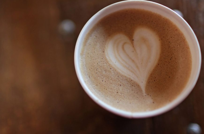 A coffee cup with a perfect frothed milk heart in the center