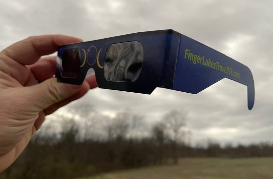 Eclipse protective glasses with "Finger Lakes Travel NY" printed on the side.