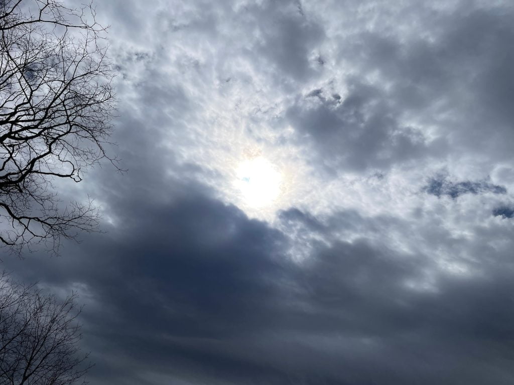 The sun at the beginning of the total eclipse shines through the clouds