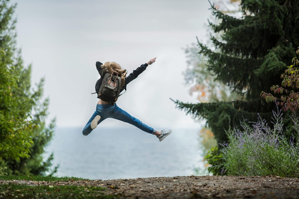 Healthy habits will make you leap for joy just like this person out in the forest.