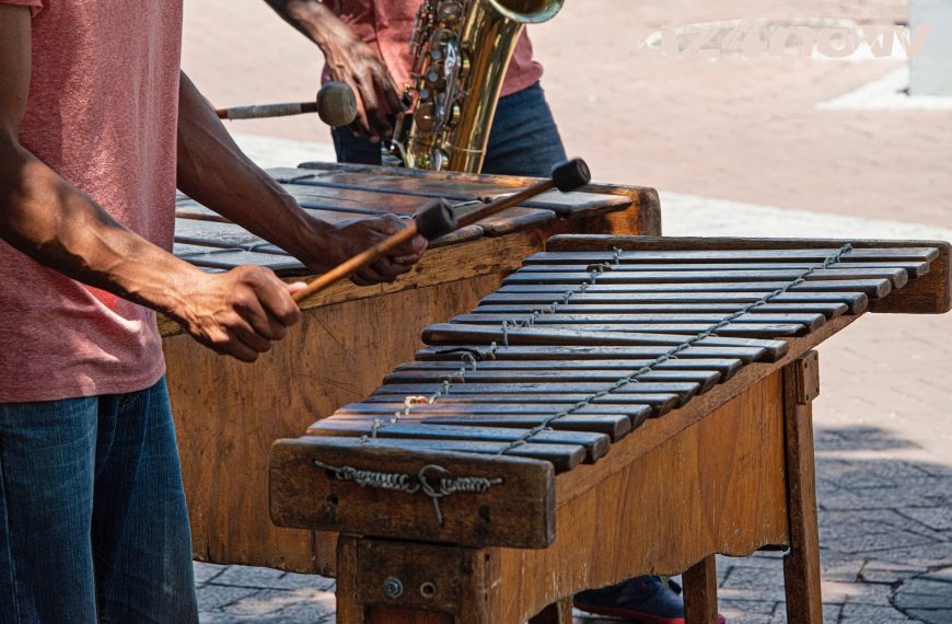 A marimba and a saxophone player give a happy vibe as they play on a street corner