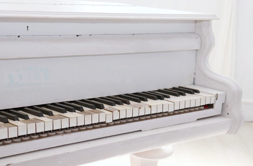 A white piano with several broken or chipped keys. A little tough to compose on this instrument.