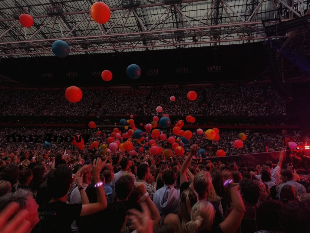 People at a concert release red and blue balloons into the air. Another kind of music release.
