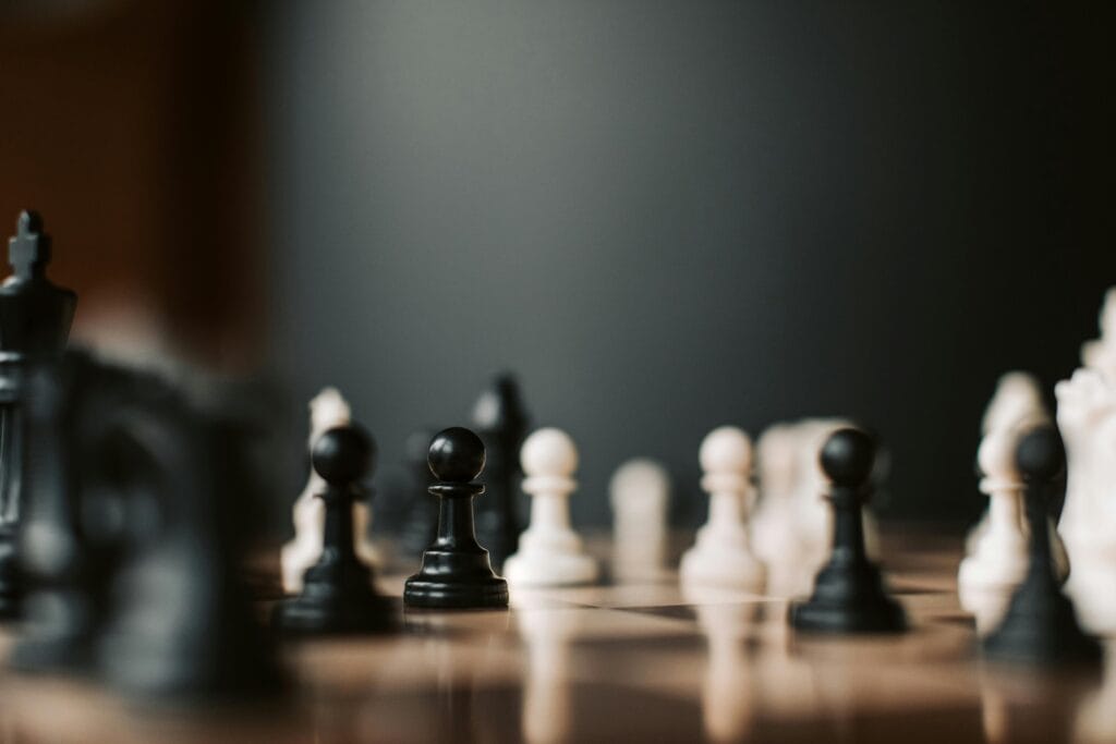 Chess pieces on a chessboard. The game has proceeded since the pieces are no longer in their starting positions.
Photo by vlada karpovich via pexels.