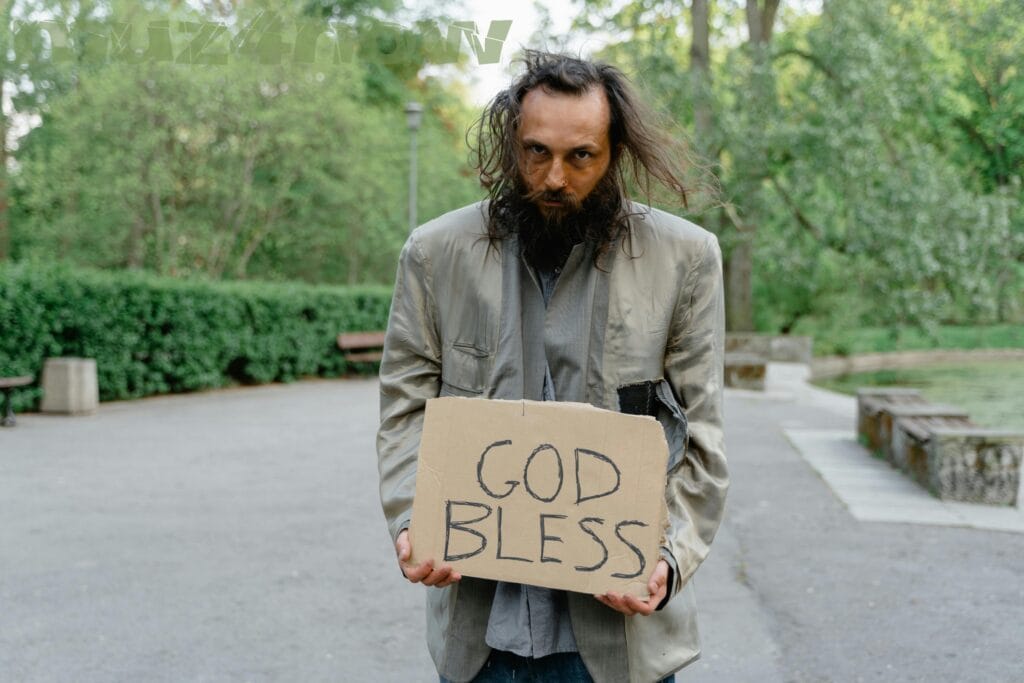 A man with long, dark hair and a beard holds a hand-written sign saying "GOD BLESS" in all-capitals. His coat is worn and torn. Behind him is what looks like a park with lots of green vegetation. All I can wonder is how he can make it in these strange times.
Visit https://www.pexels.com/@mart-production/ for this photographer's work.
