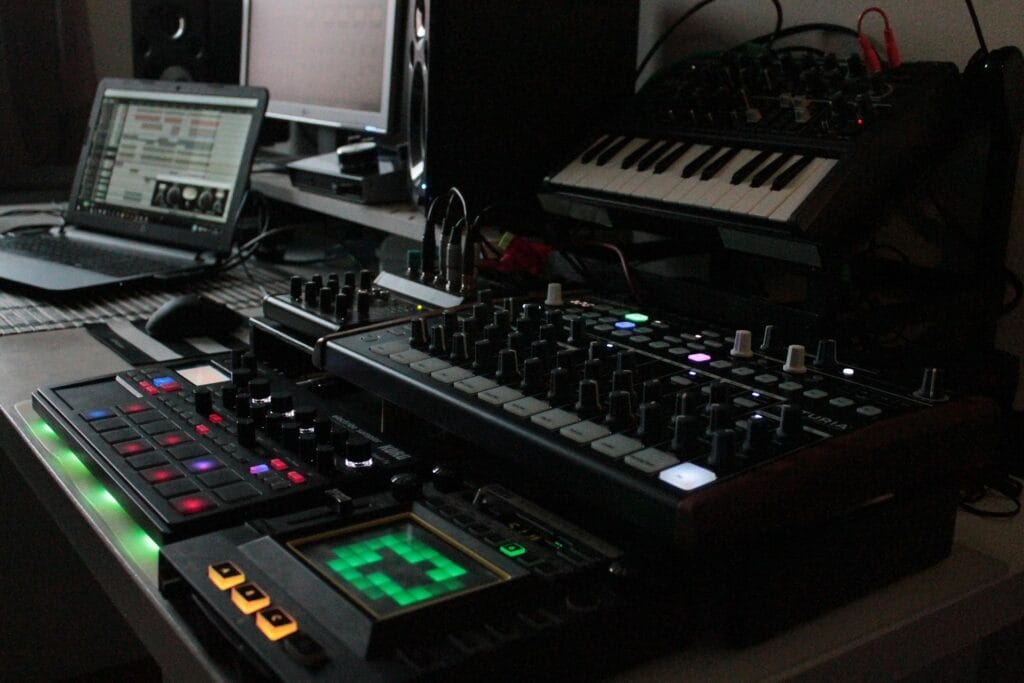 Synthesizers and controllers on a desk in front of a laptop computers.
Photo source: https://pixabay.com/users/rotten77-45238/