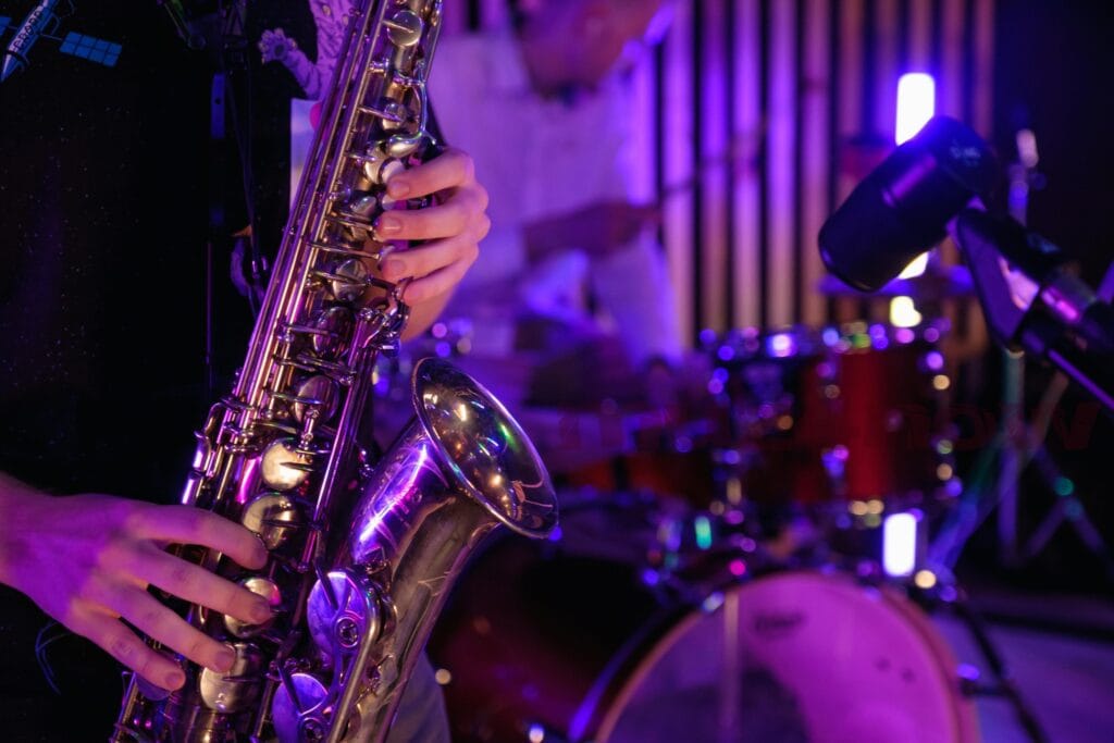 For 3 unsigned musicians: a saxophone being played near a drum kit.