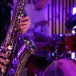 For 3 unsigned musicians: a saxophone being played near a drum kit.
