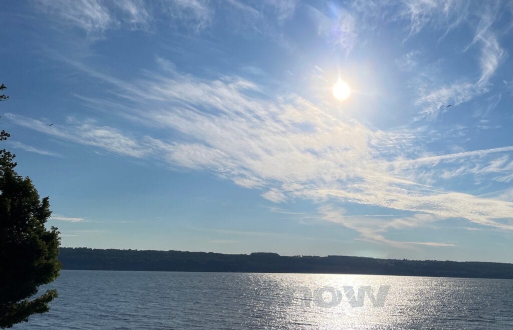 The sun through clouds, over a lake is like medicine for someone grieving.