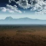 A mountain range beyond a sand covered landscape with clouds overhead represents modern parables. By https://pixabay.com/users/divotomezove-1979640/