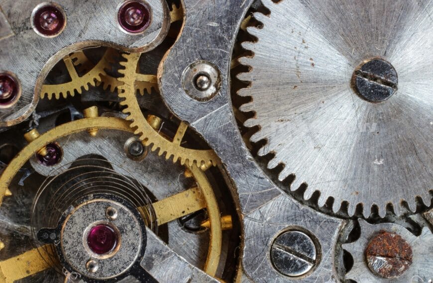 Representing generative AI, a variety of metal cogs mesh together to make a mechanism.