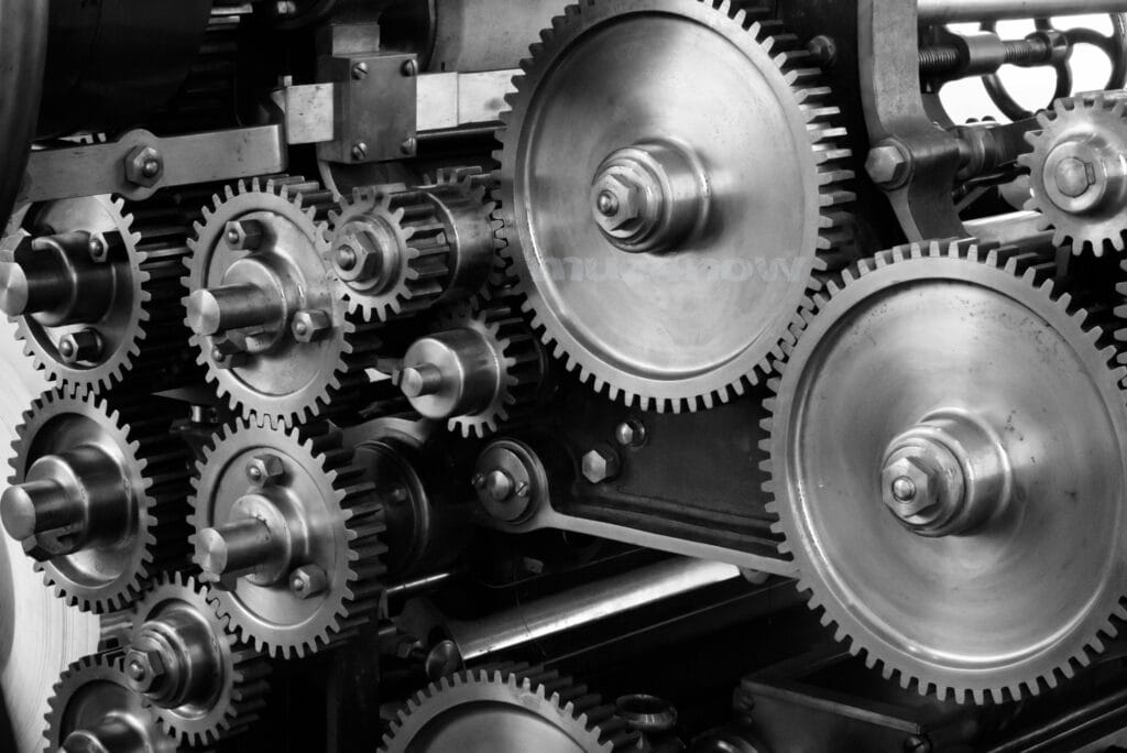 Metal cogs of various sizes mesh together in a machine.