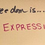 "Freedom is... EXPRESSION!" written in felt-tip marker on a beige index card. Written as a prompt for a piano improvisation concert.