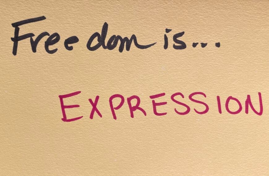 "Freedom is... EXPRESSION!" written in felt-tip marker on a beige index card. Written as a prompt for a piano improvisation concert.