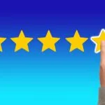 A hand with the pointing finger on the 5th of five stars as if rating in reviews.