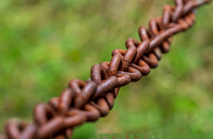 A rusty chain with blurry green background is symbolic of connection. Original photo by https://pixabay.com/users/analogicus-8164369/