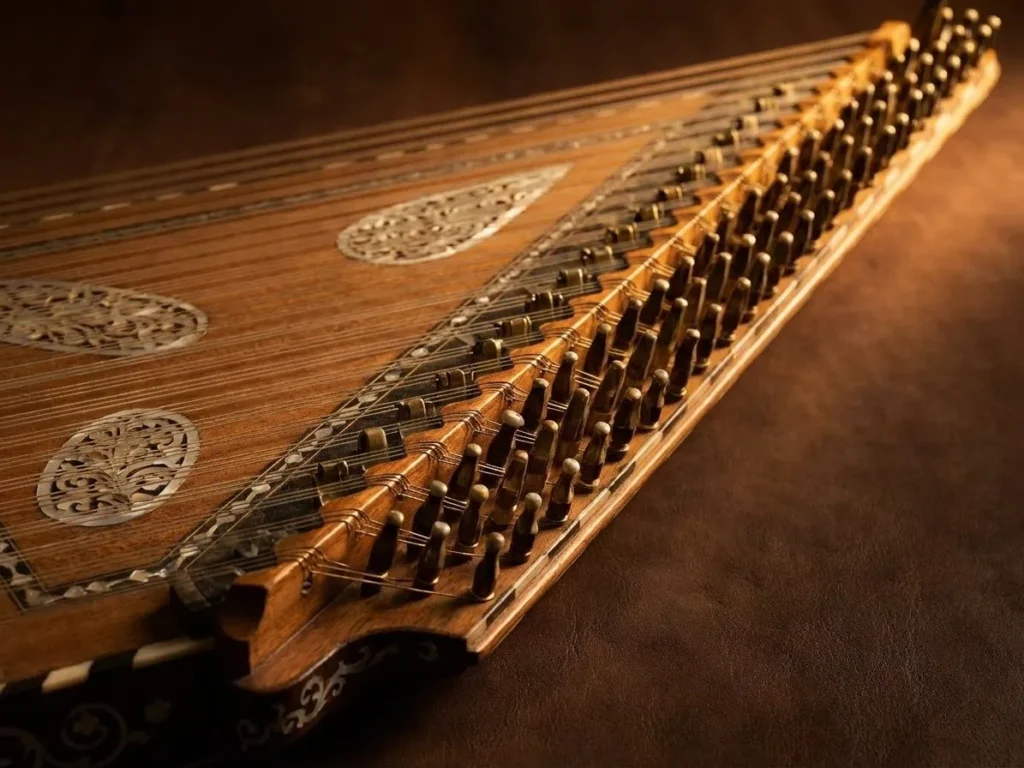 An ornate zither (multi-stringed instrument) with its many strings and tuning pegs.