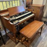 A Hammond B3 with wooden bench and Leslie speaker is next to a window. Found at https://www.reddit.com/r/hammondorgan/comments/186f7l6/my_new_acquisition_today_a_pristine_b3_with/